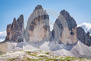 Young female is admiring Tre Cime di Lavaredo in Dolomites mountains in Italy