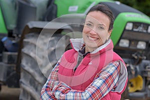 Young female agricultor on field tractor in background photo