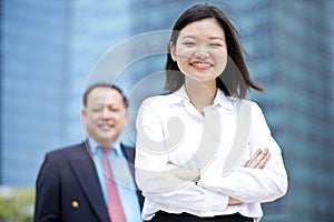 Young female Asian executive and senior Asian businessman smiling portrait