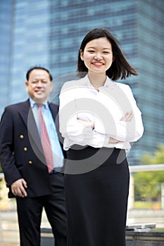 Young female Asian executive and senior Asian businessman smiling portrait
