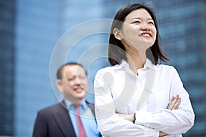 Young female Asian executive and senior Asian businessman smiling portrait