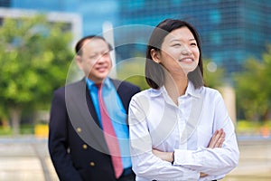 Young female Asian executive and senior Asian businessman smiling portrait