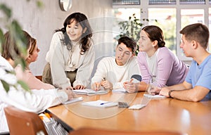 Young female asian professor explaining subject to group of students