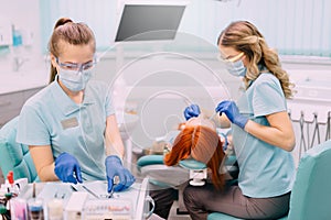 Young woman assistant prepares tools for dentist doctor