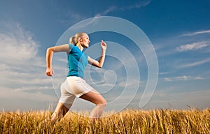 Young female athelte running across the field