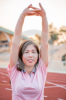 Young female athlete stretching and warming up