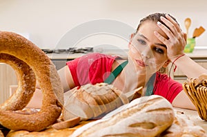 The young female baker working in kitchen