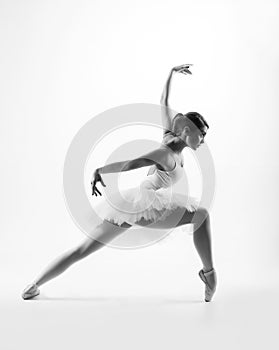 Young female ballet dancer on grey