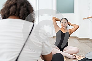 young female ballet dancer smiling looking at camera preparing before class hispanic latin woman getting ready putting on dance