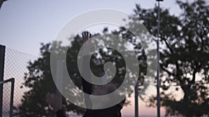 Young female basketball player plying in the morning on the local court. Young girl running with a ball and throw it