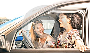 Young female best friends having fun at car roadtrip moment - Transportation concept and urban ordinary life