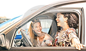 Young female best friends having fun at car roadtrip moment - Transportation concept and urban ordinary life photo