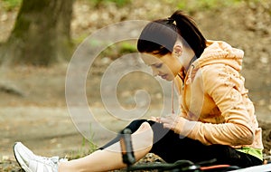 Young female bicyclist with hurt leg