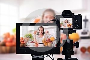 Young female blogger vlogger and online influencer recording video content on healthy food
