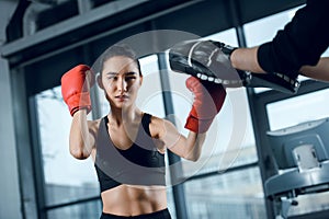 young female boxer exercising with trainer