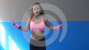 Young female boxer jumping on the skipping rope
