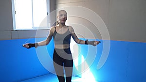 Young female boxer jumping on the skipping rope