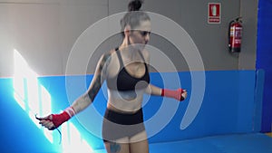 Young female boxer jumping on the skipping rope