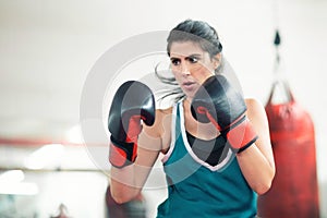 A young female boxer punching a bag in the gym
