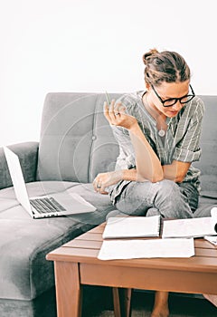 Young female businesswoman student working on project with laptop at home, studying for exams, home office concept