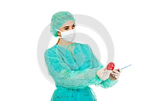 Young female cardiologist surgeron holding heart and scalpel