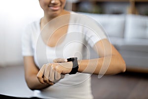 Young female checking pulse on smartwatch during break