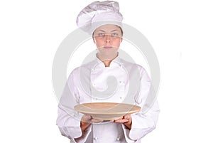 Young female chef showing a wooden dish