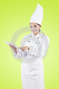 Young female chef using a tablet in the studio