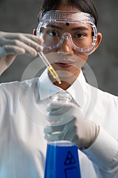 Young female chemist doing science experiment with chemicals