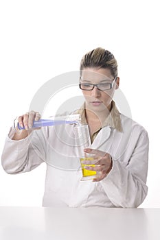 Young female chemist pours liquids together