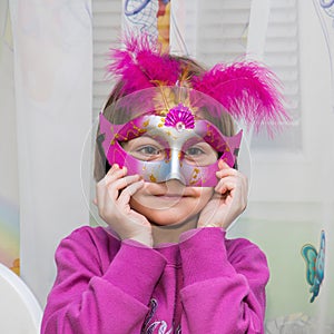 Young female child with red Mardi Gras mask