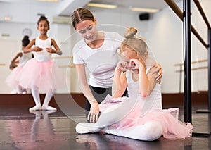 Ballet teacher comforting tired little ballerina