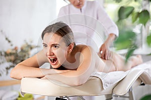 Young female client dissatisfied with work of masseuse