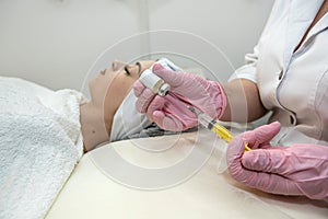 Young female client receiving cosmetology treatment botox injection at spa clinic