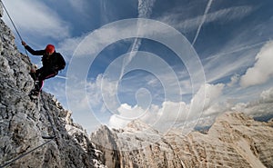 Young female climber on an exposed Via Ferrate in the Dolomites