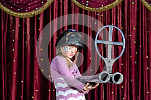 Young Female Clown in Helmet Aiming Large Rifle