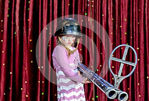 Young Female Clown in Helmet Aiming Large Rifle