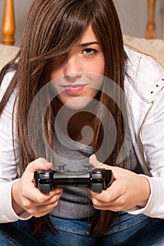 Young female concentrating playing video-games photo