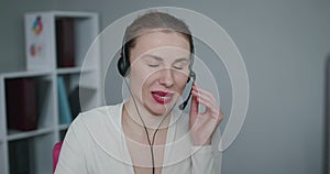 Young female customer service agent talking to a customer with a telephony headset as she looks at the camera.