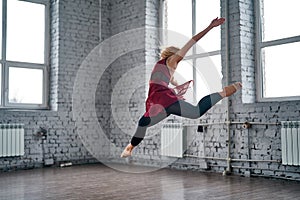 Young female dancer jumping and dancing in the gym.