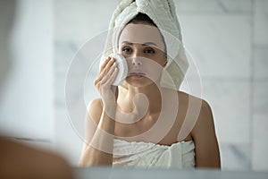 Young female with delicate sensitive skin trying new facial sponge photo