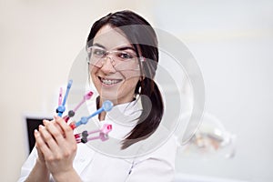 Young female dentist holding equipment