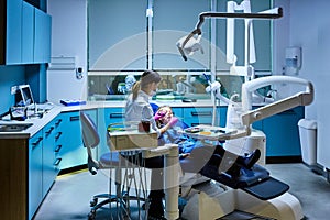 Young female dentist working in her office.