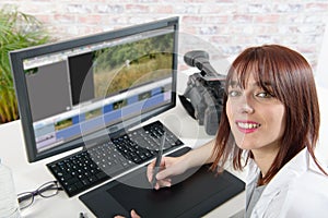 Young female designer using computer for video editing