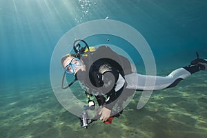 Young female diver in clear blue water.