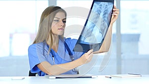 Young Female Doctor Examing X-ray of Patient, Lungs and Ribcage