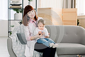 Young female Doctor examining a little baby girl by stethoscope. Baby in doctor`s office for medical checkup