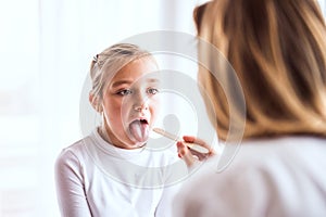 Young female doctor examining a small girl in her office.