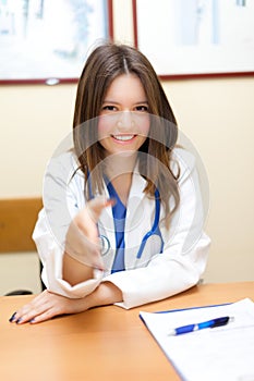 Young female doctor giving her hand