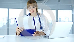 Young Female Doctor Holding Medical Reports, Talking with Patient